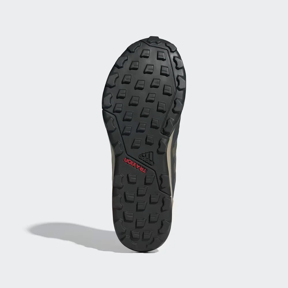 Close-up of a black shoe sole with tread pattern on a light gray background