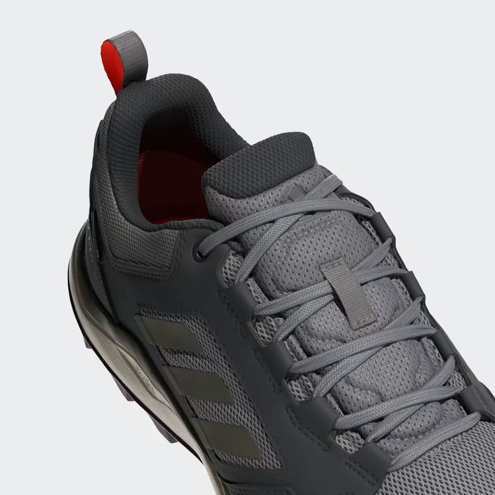 Gray athletic shoe with red accent on a light gray background