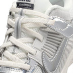 Macro close-up angle capturing the textured elastic laces, tongue badge, and side ventilation caging.