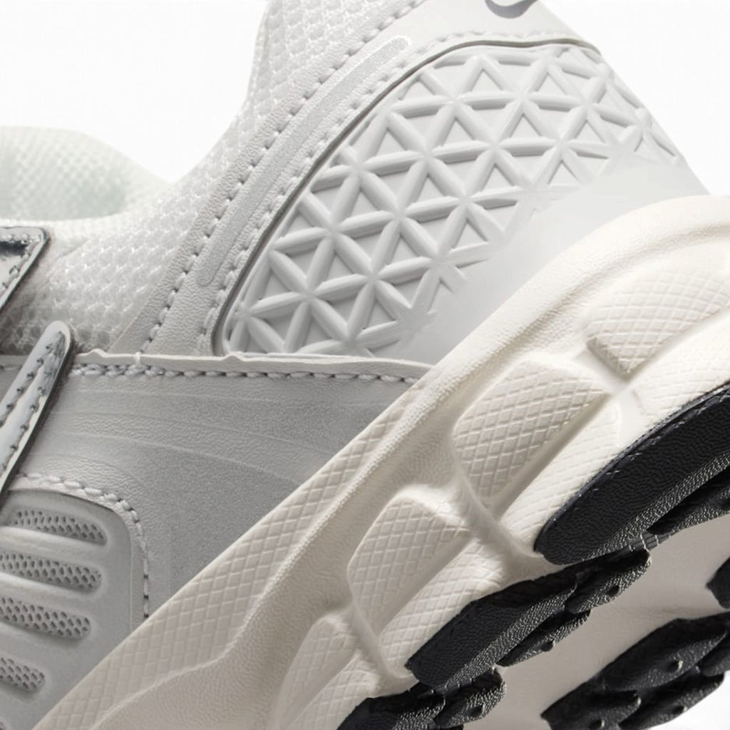 Detailed close-up angle focusing on the geometric molded heel pattern and textured midsole sidewall.