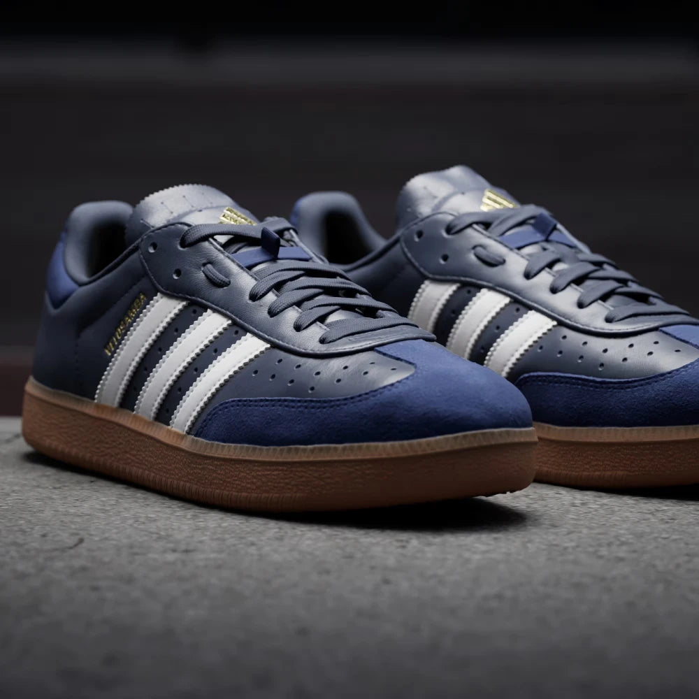 Details the premium dual-stitching lines tracing the iconic T-toe reinforcement panels and the precision layout of the lace eyes.