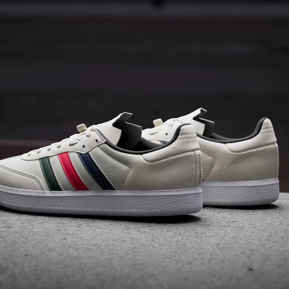 White sneakers with colorful stripes on a dark background