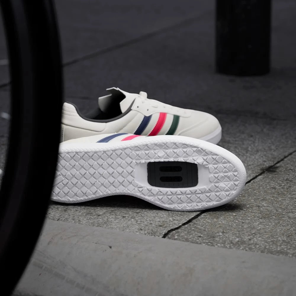 White sneakers with colorful stripes on a concrete surface