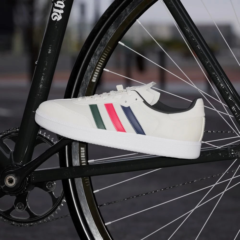White sneaker with colorful stripes on a bicycle wheel