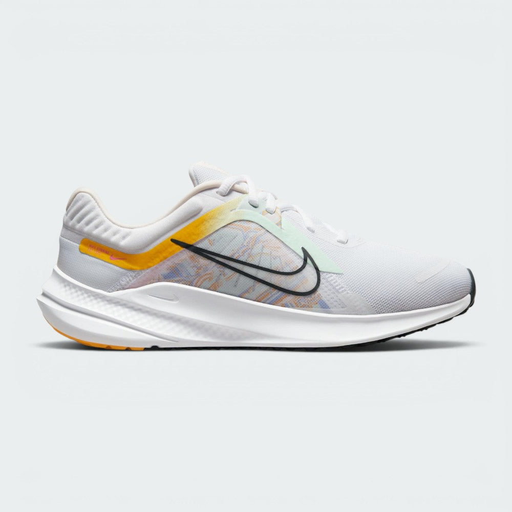 Highlights the high-velocity sweep of the University Gold Nike Swoosh, showing the clean texture of the white mesh upper, the subtle pale pink midsole accenting, and the sleek dark smoke grey rubber outsole line. Main image