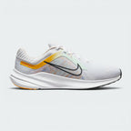 Highlights the high-velocity sweep of the University Gold Nike Swoosh, showing the clean texture of the white mesh upper, the subtle pale pink midsole accenting, and the sleek dark smoke grey rubber outsole line.