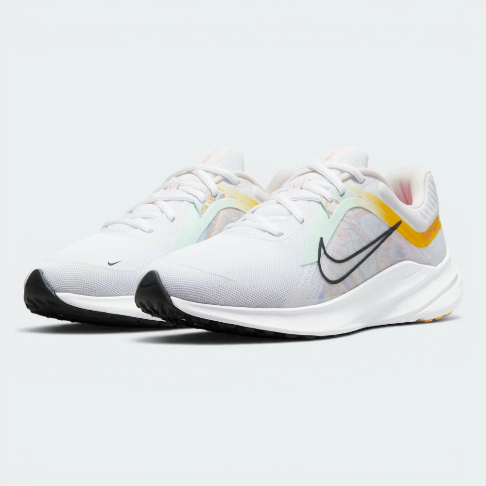 Emphasising the low-cut, athletic running stance and the professional harmony of the university gold and pale pink contrast panels against the neutral white background.