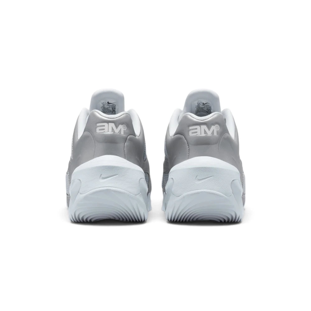 Focuses on the rear profile, highlighting the raised metallic silver heel counters stamped with white "aM" Air Max logos, and the wide flared footprint of the sculpted white foam heel base.