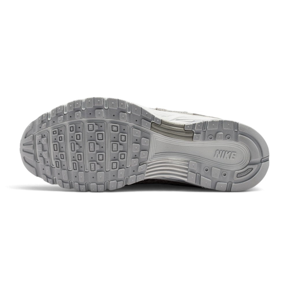 Full-length bottom profile showing the hard-wearing rubber outsole, displaying the heritage Waffle-inspired square traction lugs, multi-directional perimeter pods, deep forefoot flex grooves, and debossed central Nike Swoosh.