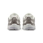 Close-up rear angle focusing on the structured synthetic and snakeskin suede heel counter, miniature embroidered silver Swoosh logo, padded collar notch, and bevelled athletic foam midsole heel stack.