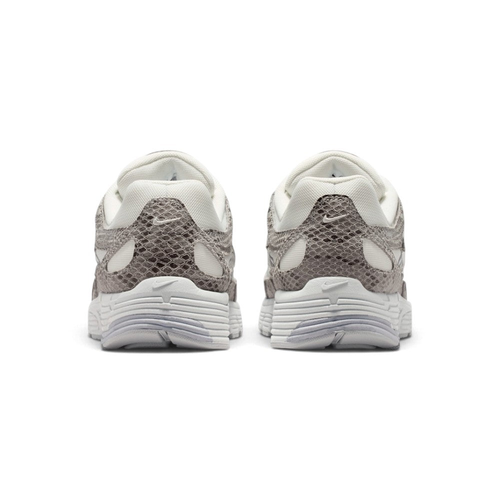 Close-up rear angle focusing on the structured synthetic and snakeskin suede heel counter, miniature embroidered silver Swoosh logo, padded collar notch, and bevelled athletic foam midsole heel stack.