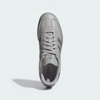 Top-down view of the trainers, highlighting the grey shoelace tying system and the signature T-toe suede overlay.