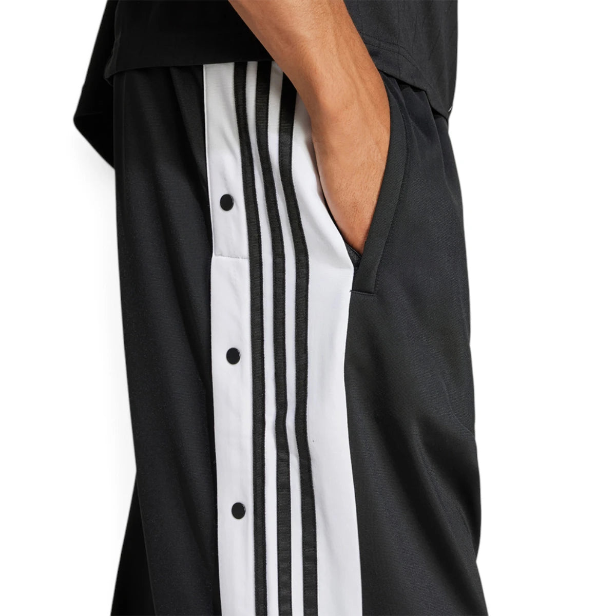 Macro close-up angle capturing the textured tricot fabric weave, clean stitching lines, and the precise entry of the functional side pocket.