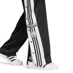 Detailed close-up angle focusing on the branded snap-button hardware and the classic woven Adibreak label positioned near the lower hem.