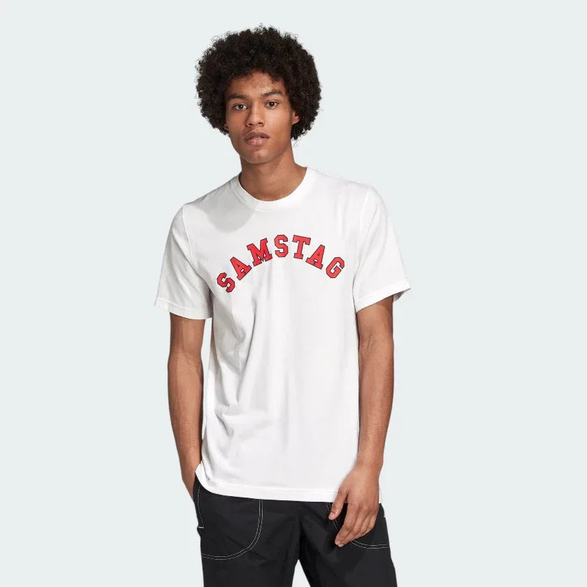 A man wearing a white Adidas t-shirt with the word 'SAMSTAG' printed in red letters across the chest.