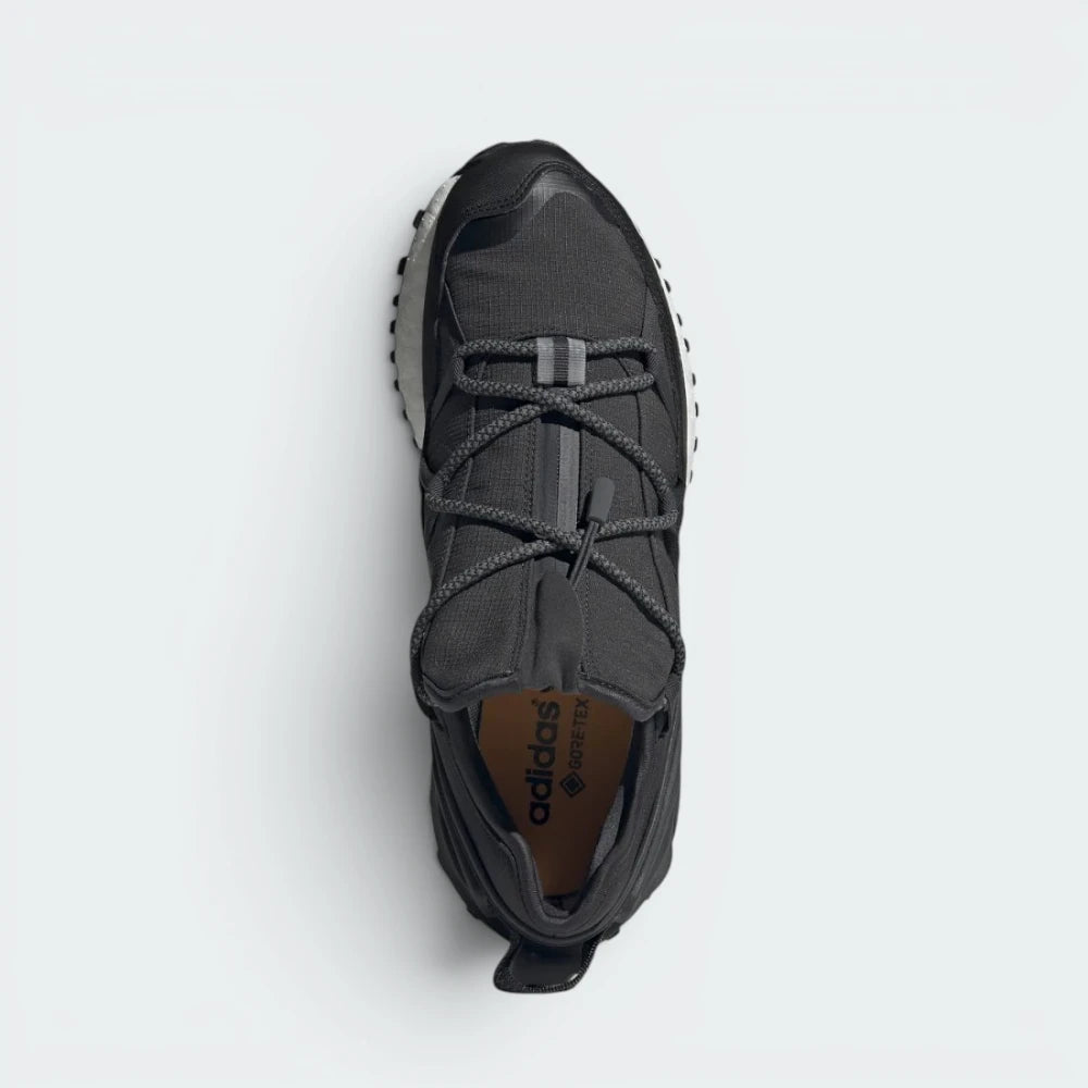 Focuses on the locked-in shroud design and the professional adidas branding on the tongue.