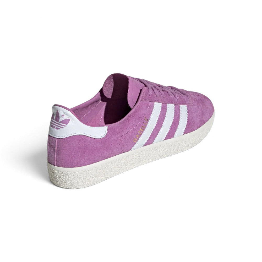 Focuses on the rear profile, displaying the Cloud White smooth leather heel moustache tabs stamped with purple Trefoil emblems, neat tonal stitch lines, and the low-slung rubber cupsole rim.