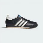 Black Adidas sneaker with white stripes on a light gray background