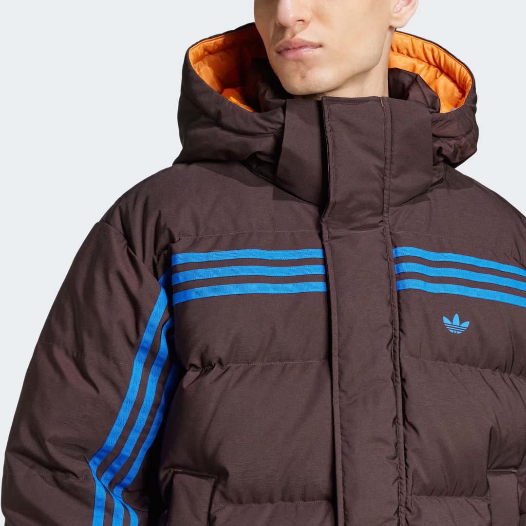 Close-up zoom on the fabric of the Adidas Premium Puffer Jacket, showing the quilted texture and the embroidered Adidas logo.