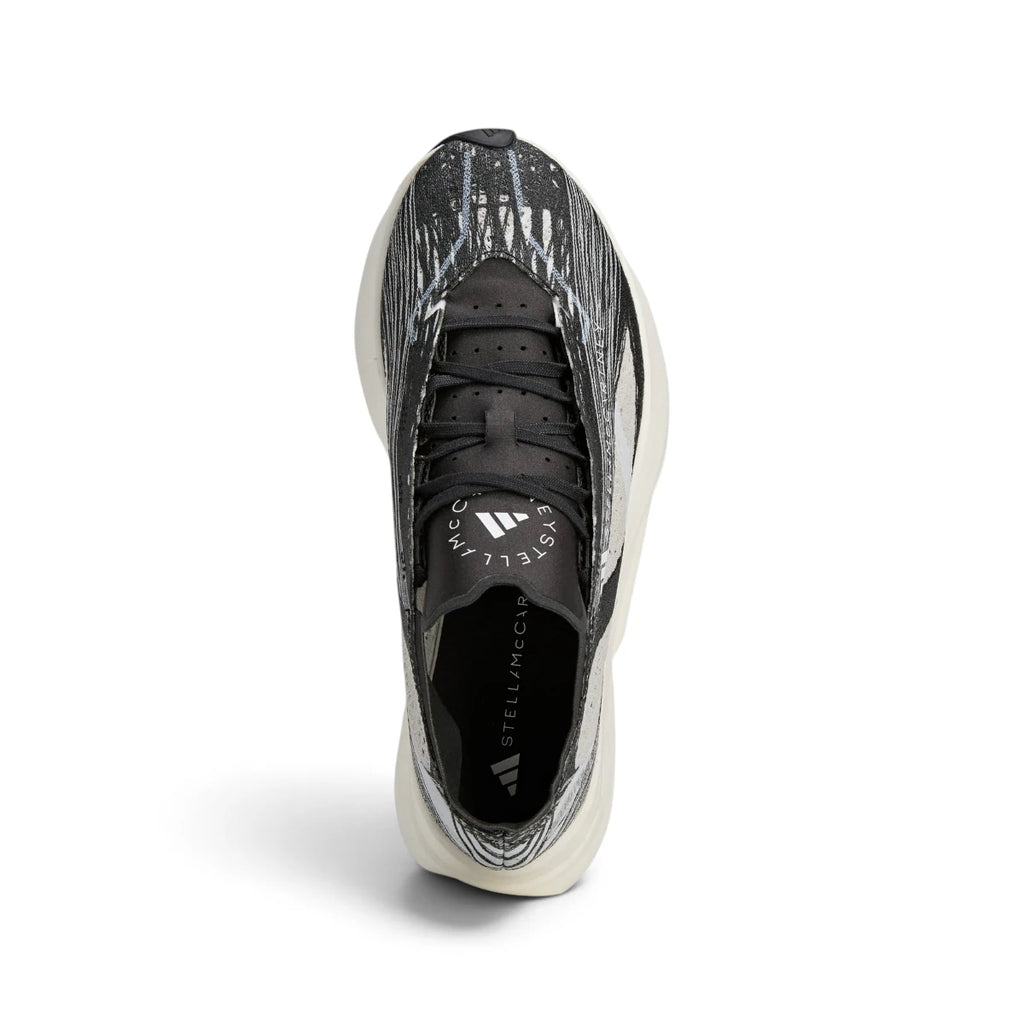 Overhead view looking down at the laced running shoes, displaying the black flat laces, co-branded Stella McCartney tongue badge, and streamlined collar opening.
