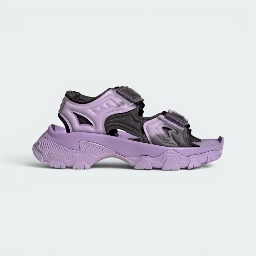 Highlights the high-velocity curves of the chunky, rugged EVA sole unit and the professional layering of the Purple Glow straps.