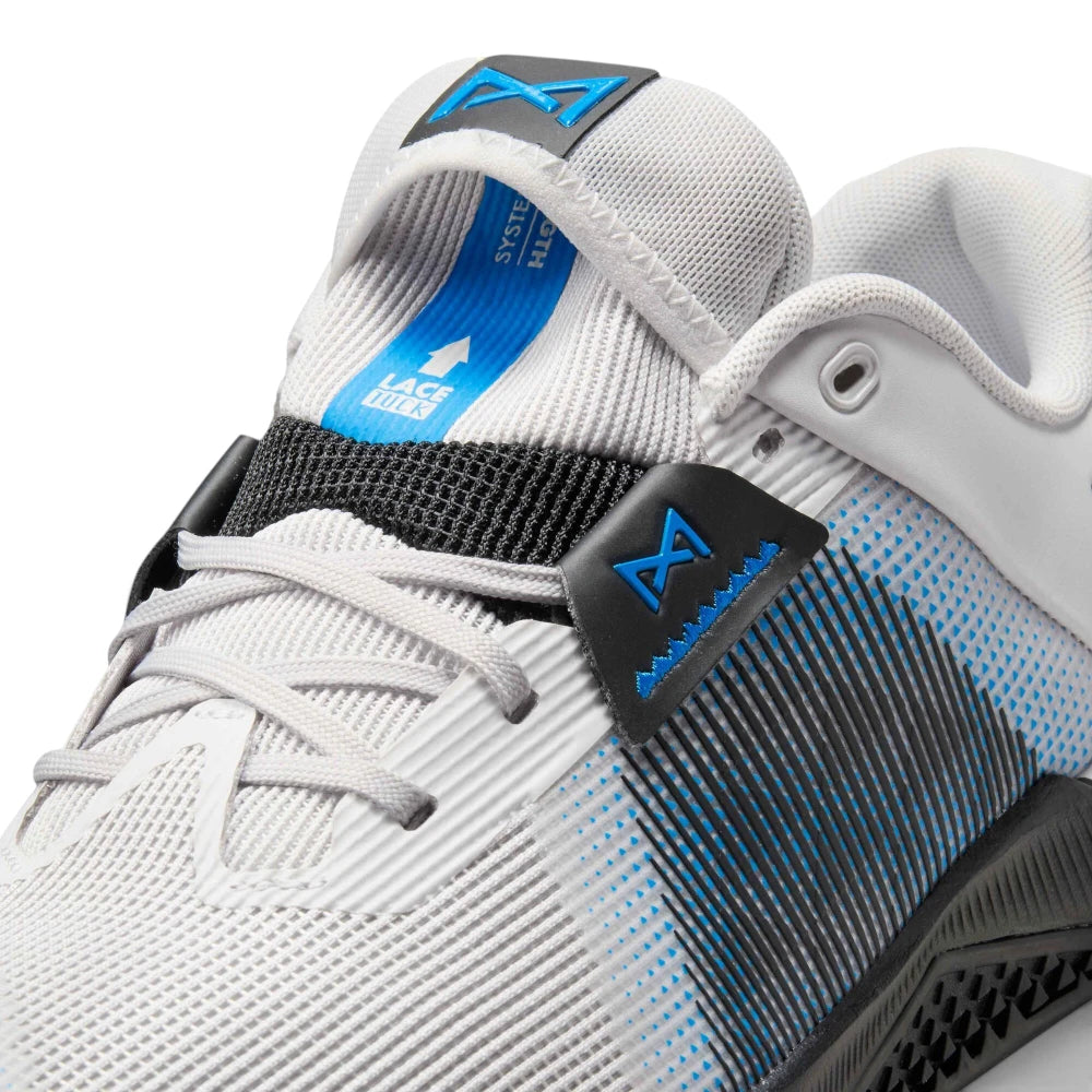 Detailed close-up angled at the upper eyelets, padded tongue, and lacing area, highlighting the blue "Lace Tuck" mechanism, black woven strap, and reinforced grey mesh.