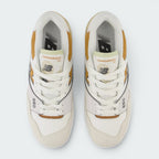 Focuses on the locked-in central lacing layout, displaying the symmetry of the white mesh tongue, matching laces, orange basketball tongue tag graphics, and black "NB" branding printed on the grey insoles.
