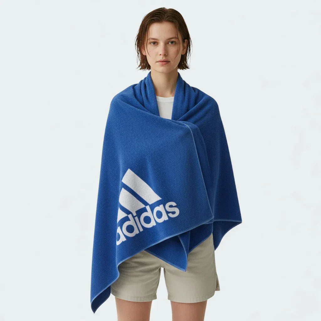 Person wearing a blue Adidas towel on a white background
