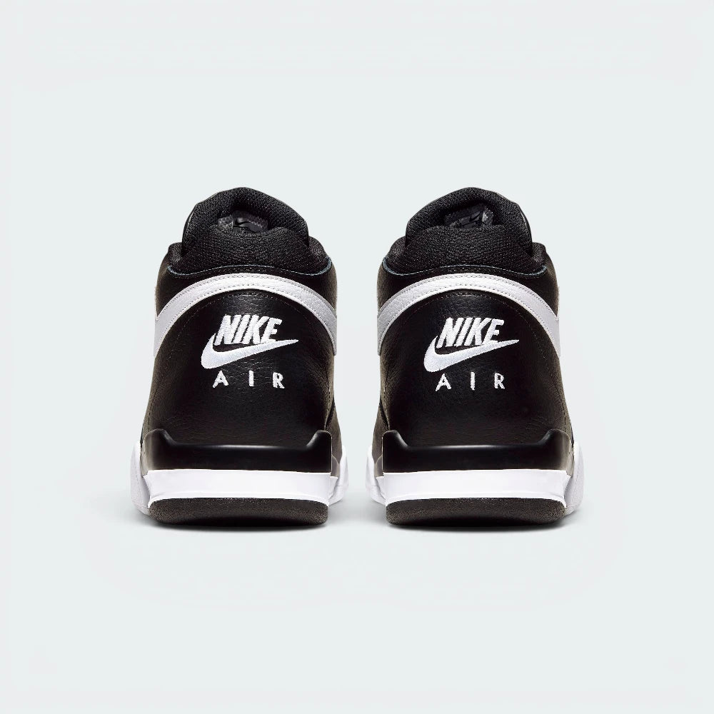 Focuses on the contoured shape of the padded mid-cut collar, highlighting the seamless black leather heel cup and the clean, wide footprint of the sole unit below.