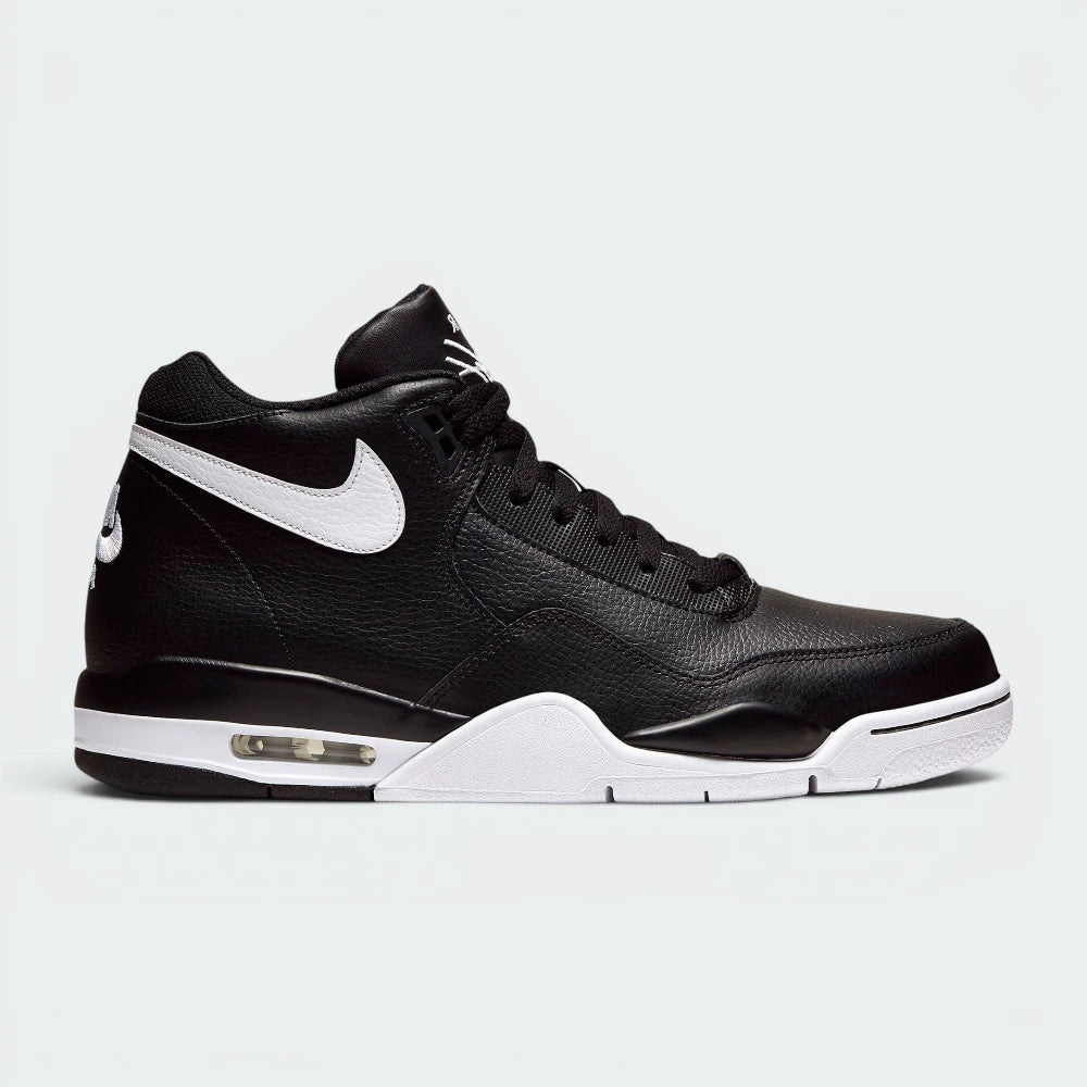 Highlights the high-velocity sweep of the contrasting white Nike Swoosh, showing the professional, multi-paneled black leather upper, the padded mid-top ankle collar, and the visible heel Air window embedded in the white midsole wall. Main image