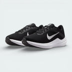 Angled view of two Nike Winflo 10 Women's trainers side by side, showcasing the modern athletic silhouette and contrasting black and white design.