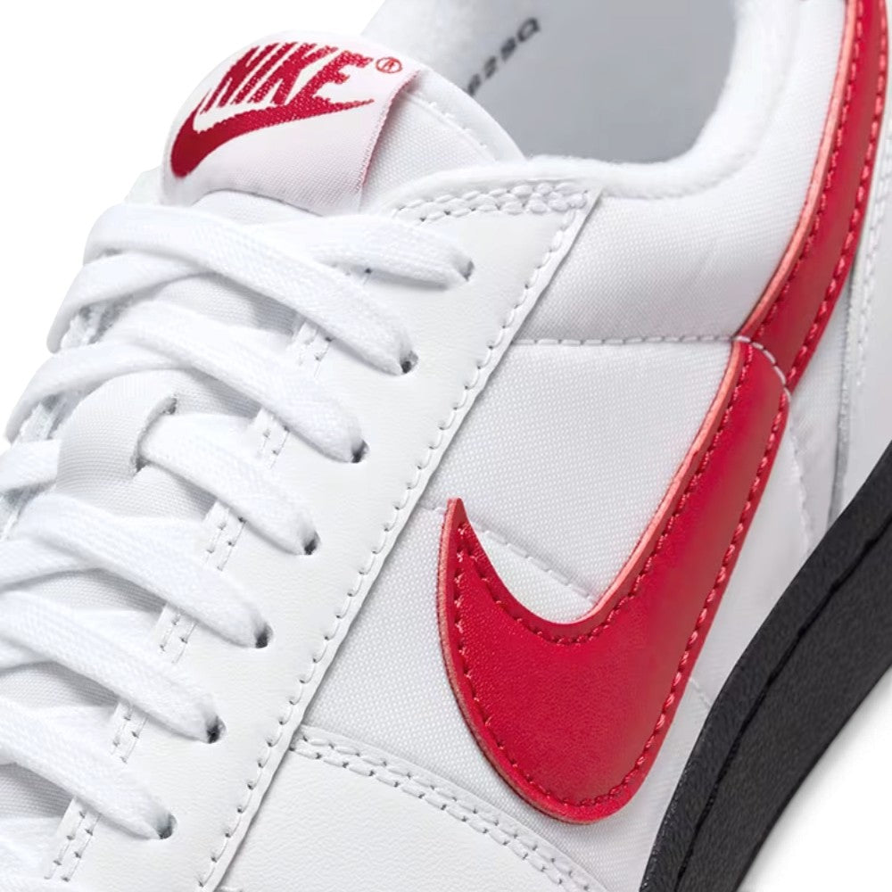 Close-up of the forefoot showing the vintage red tongue label, white laces, and the leather-and-textile upper construction.