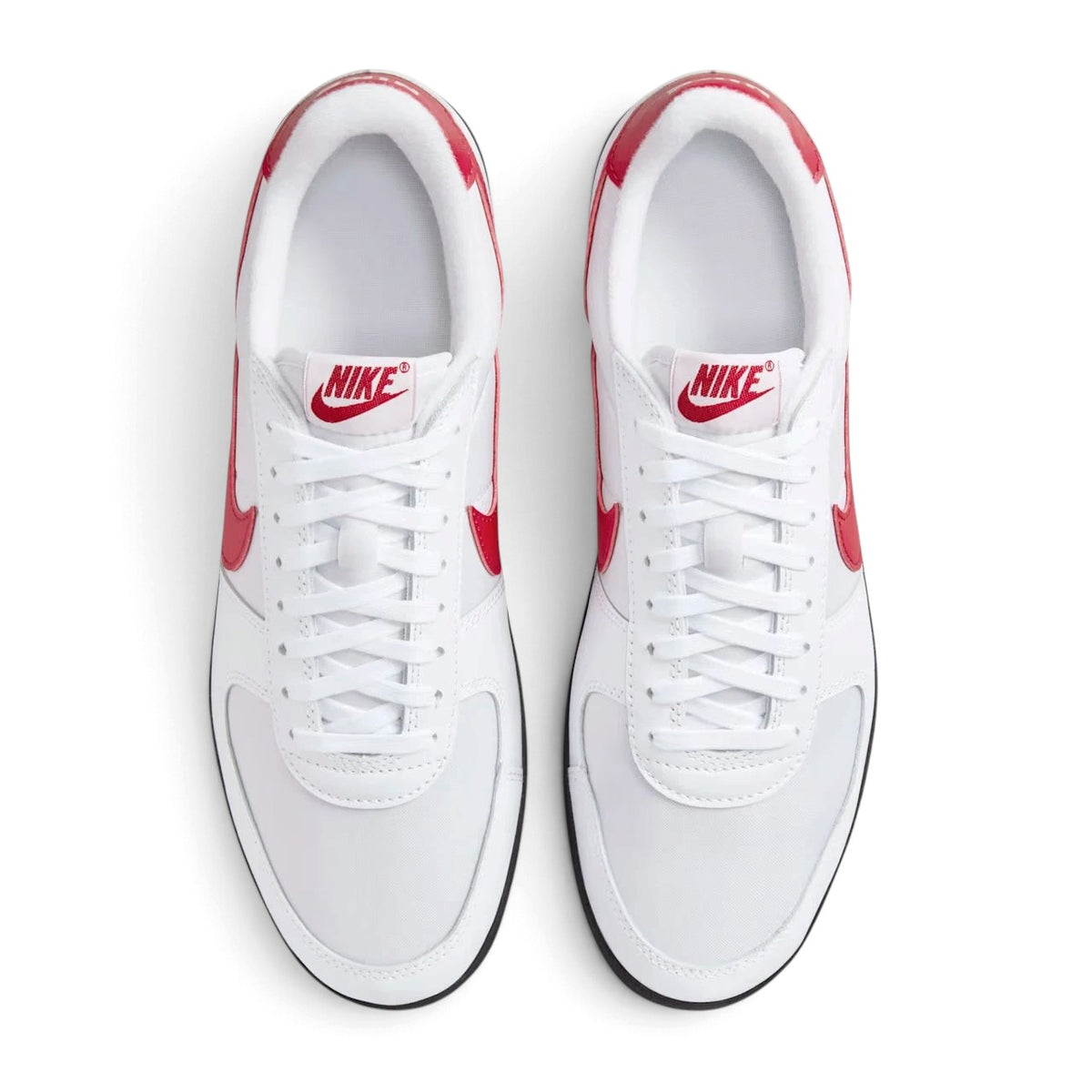 Top-down view of both sneakers placed side by side, highlighting the white textile toe boxes, white laces, and vintage red tongue logos.
