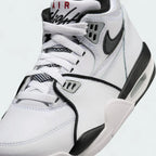 Close-up zoom on the front of the Nike Air Flight 89 Juniors' white trainers, showing the perforated toe box, lacing system, and texture of the leather upper.