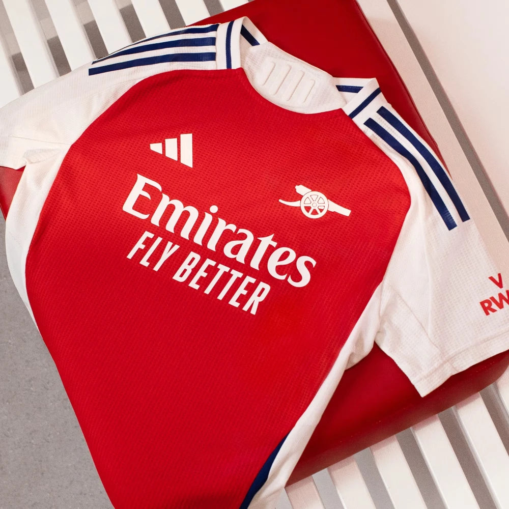 Red sports jersey with Emirates logo on a white background
