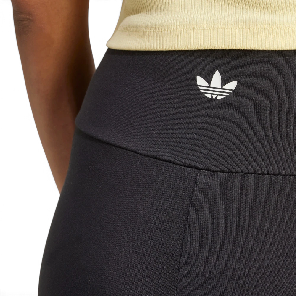 Close-up view of the back of the waistband, showing the fine-knit black fabric, neat flatlock stitching, and the printed white adidas Trefoil logo centered on the rear.