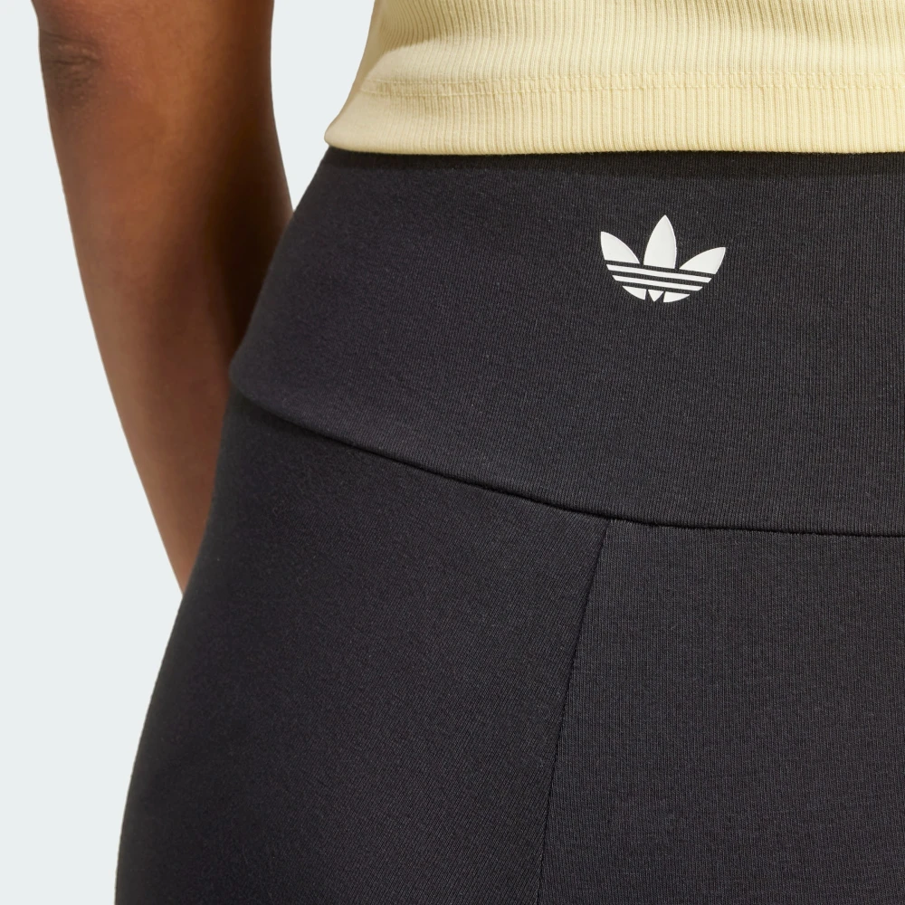 Close-up view of the back of the waistband, showing the fine-knit black fabric, neat flatlock stitching, and the printed white adidas Trefoil logo centered on the rear.