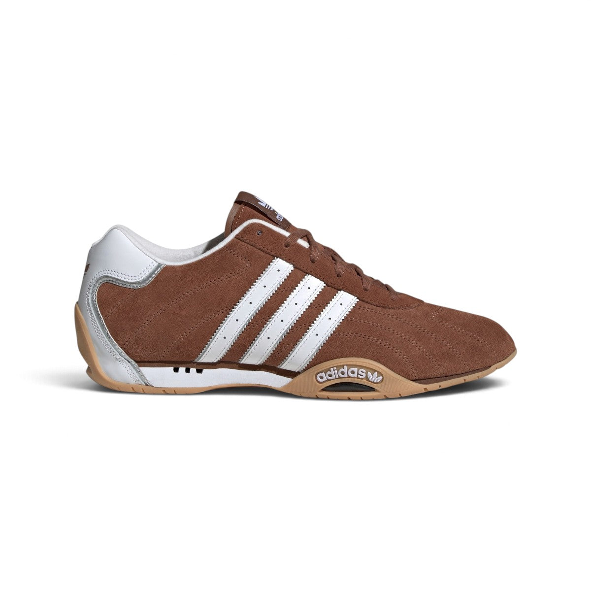 Studio lateral shot of the adidas Adi Racer Lo shoes in Preloved Brown, Cloud White, and Silver Metallic, highlighting the low-profile brown suede upper, white serrated three-stripes, silver reflective piping, and slim gum rubber sole.