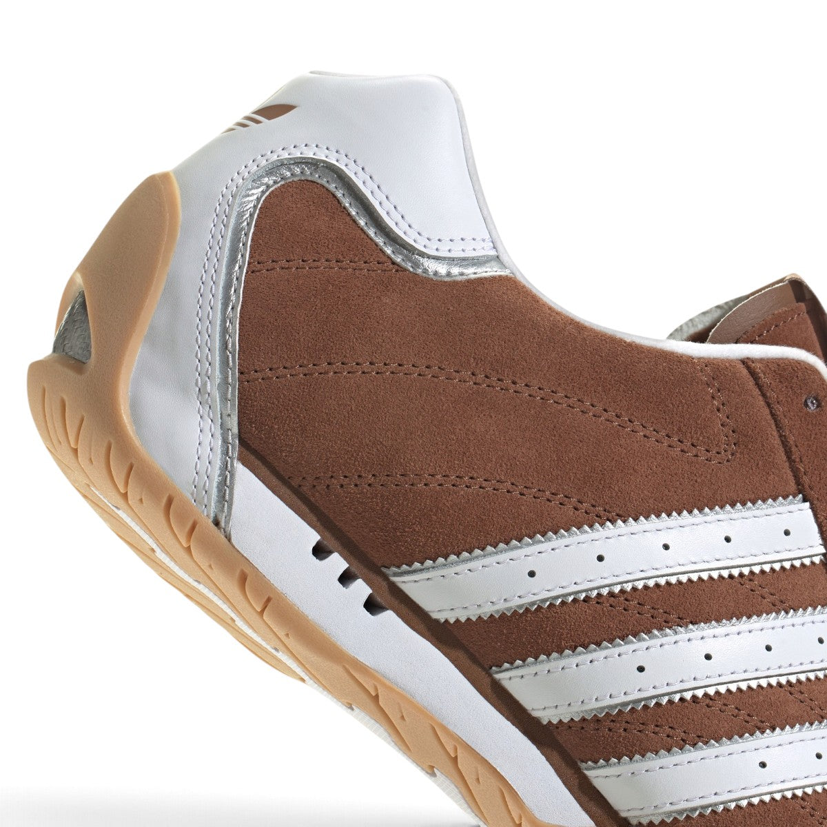 Macro close-up angle capturing the precision double cross stitching lines, reflective silver piping, and perforated white leather panels.