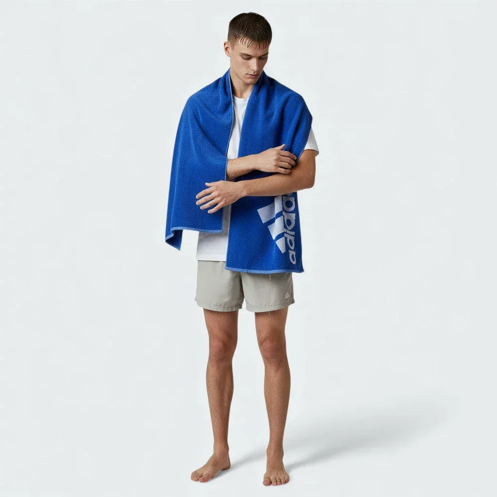 Person holding a blue towel with a brand logo on a white background Main image