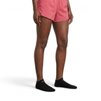 Person wearing pink shorts and black ankle socks on a plain background