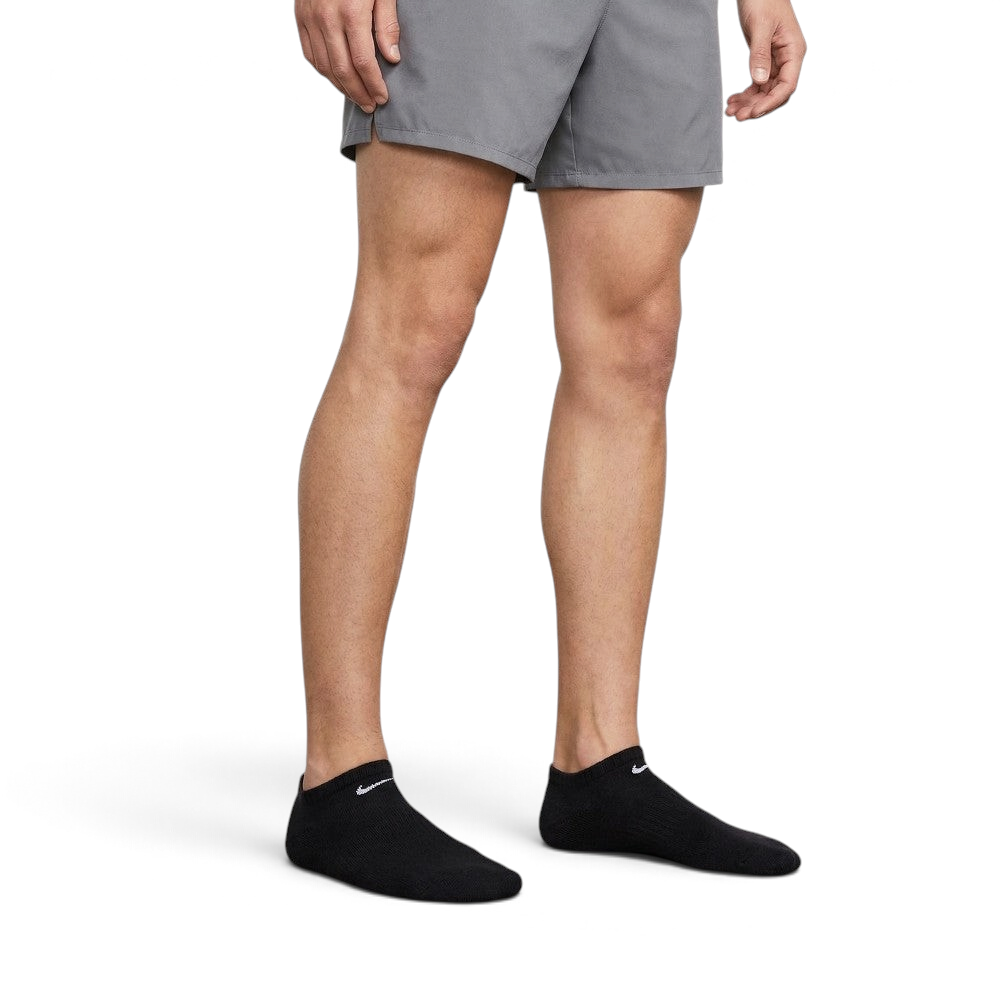 Person wearing gray shorts and black ankle socks with Nike logo on a neutral background