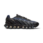 Highlights the futuristic lateral profile showing the Black and Thunder Blue gradient mesh upper, flame-like Wolf Grey sculpted overlays, a mini Metallic Silver Swoosh, structured black TPU heel counter clip, and the eight visible pressurized Dynamic Air tubes set into the black sculpted midsole.