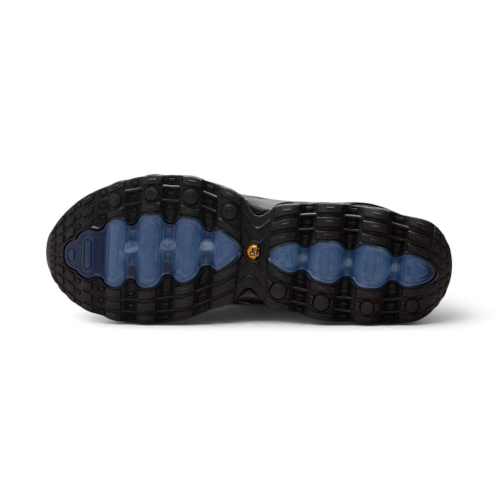 Highlights the futuristic lateral profile showing the Black and Thunder Blue gradient mesh upper, flame-like Wolf Grey sculpted overlays, a mini Metallic Silver Swoosh, structured black TPU heel counter clip, and the eight visible pressurized Dynamic Air tubes set into the black sculpted midsole.