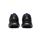 Focuses on the rear profile, displaying the contoured black plastic heel clips, circular yellow-and-white "Air Max Dn" heel badges, blue gradient collar mesh, and the flared base of the rubber outsole.