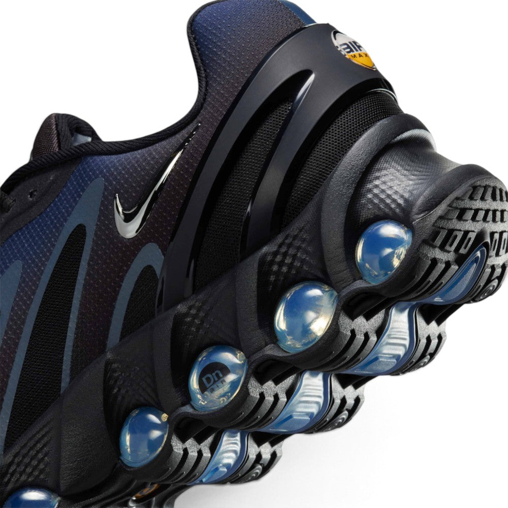 Highlights the "unreal" clean finish of the rear lateral tooling, showcasing the black contoured heel clip, glossy mini Swoosh, textured foam carrier, and the individual pressurized blue Dynamic Air tubes—including the tube stamped with "Dn air" lettering.