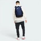 Focuses on the complete dimensional footprint of the bag, emphasizing the vibrant white corporate Nike Swoosh graphic on the front panel against the deep navy backing.