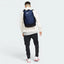 Focuses on the complete dimensional footprint of the bag, emphasizing the vibrant white corporate Nike Swoosh graphic on the front panel against the deep navy backing.