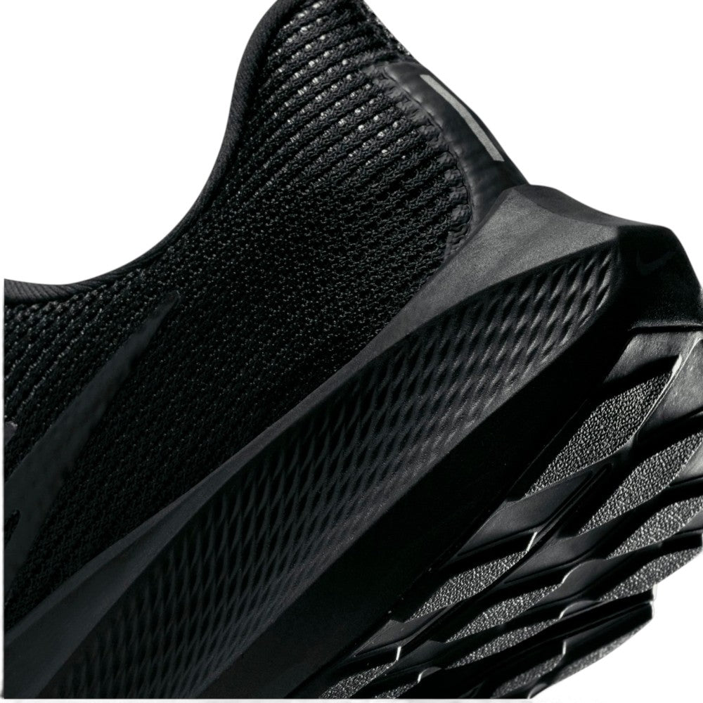 Angled macro view focusing on the textured diamond patterning on the black Nike React midsole wall, lateral outsole crash rail lugs, and heel bevel geometry.