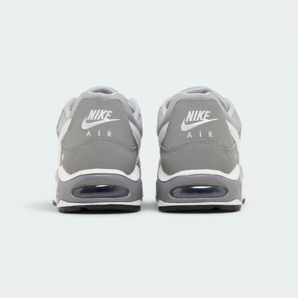 Focuses on the contoured shape of the padded low-cut collar, highlighting the embroidered Nike Air logo on the heel tab sitting squarely above the robust heel frame and the translucent Air window.